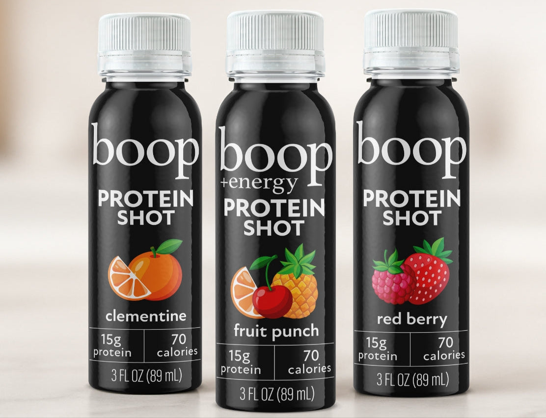 Three bottles of boop protein shots with different flavors on a light background